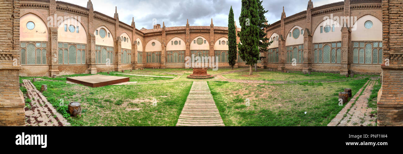 The internal cloister of the Nuestra Señora de la Huerta gothic and mudejar cathedral, with a tree and a path to walk in the grass, in Tarazona, Spain Stock Photo