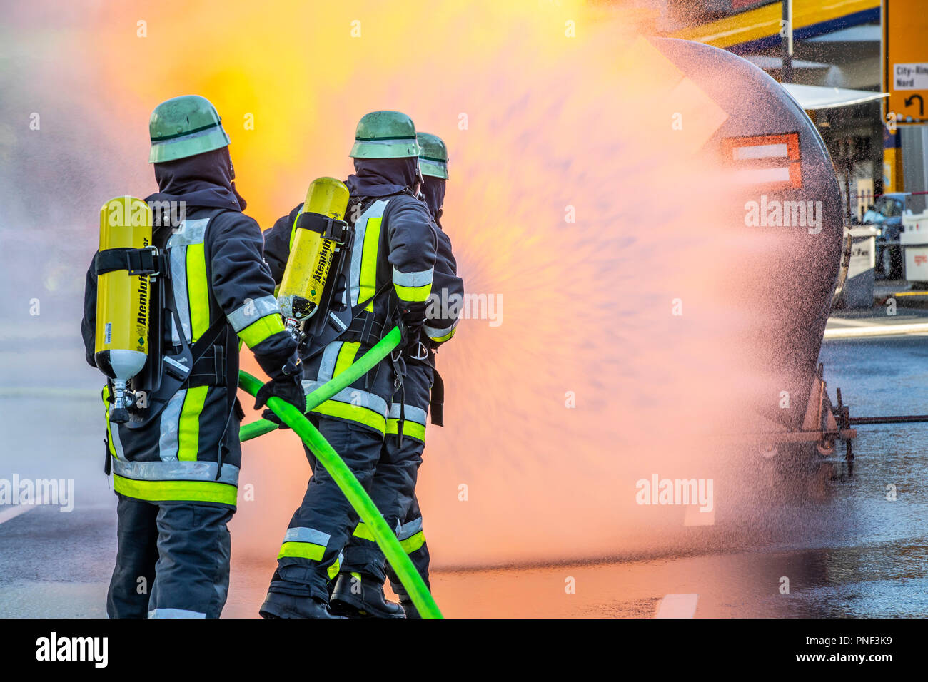 Firefighters with a hose wearing breathing apparatus, UK Stock Photo - Alamy