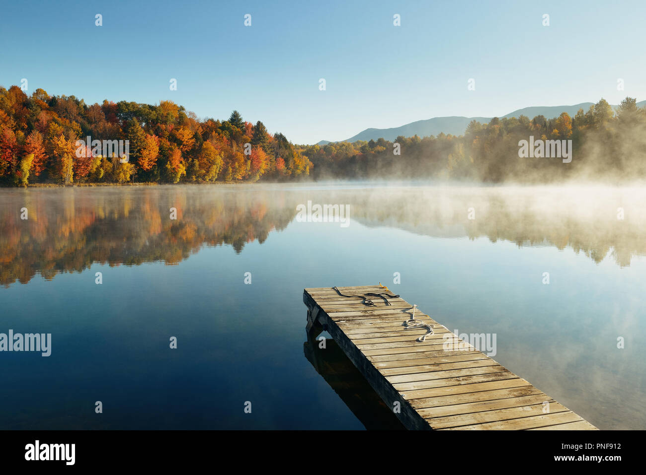 Autumn Foliage And Fog Lake In Morning With Boat Dock Stock Photo - Alamy