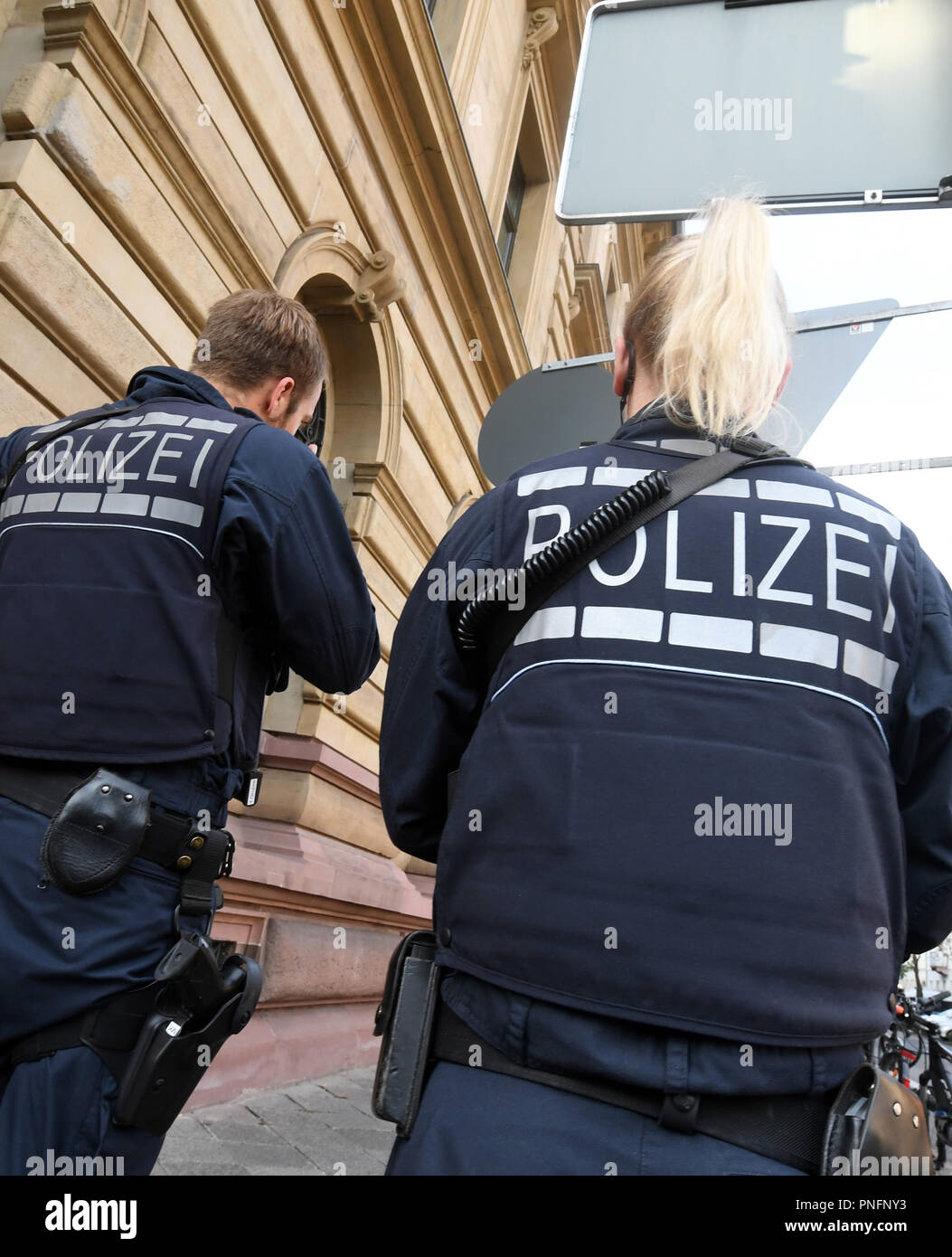 21 September 2018, Baden-Wuerttemberg, Karlsruhe: Police officers stand before the Karlsruhe Regional Court for the start of a mafia trial. Nine men aged 26 to 57 living in the Black Forest Baar district, Stuttgart and Italy are accused of dealing drugs on a large scale from October 2013, some of them as organised gangs from November 2016 at the latest until their arrests in June 2017. Photo: Uli Deck/dpa Stock Photo