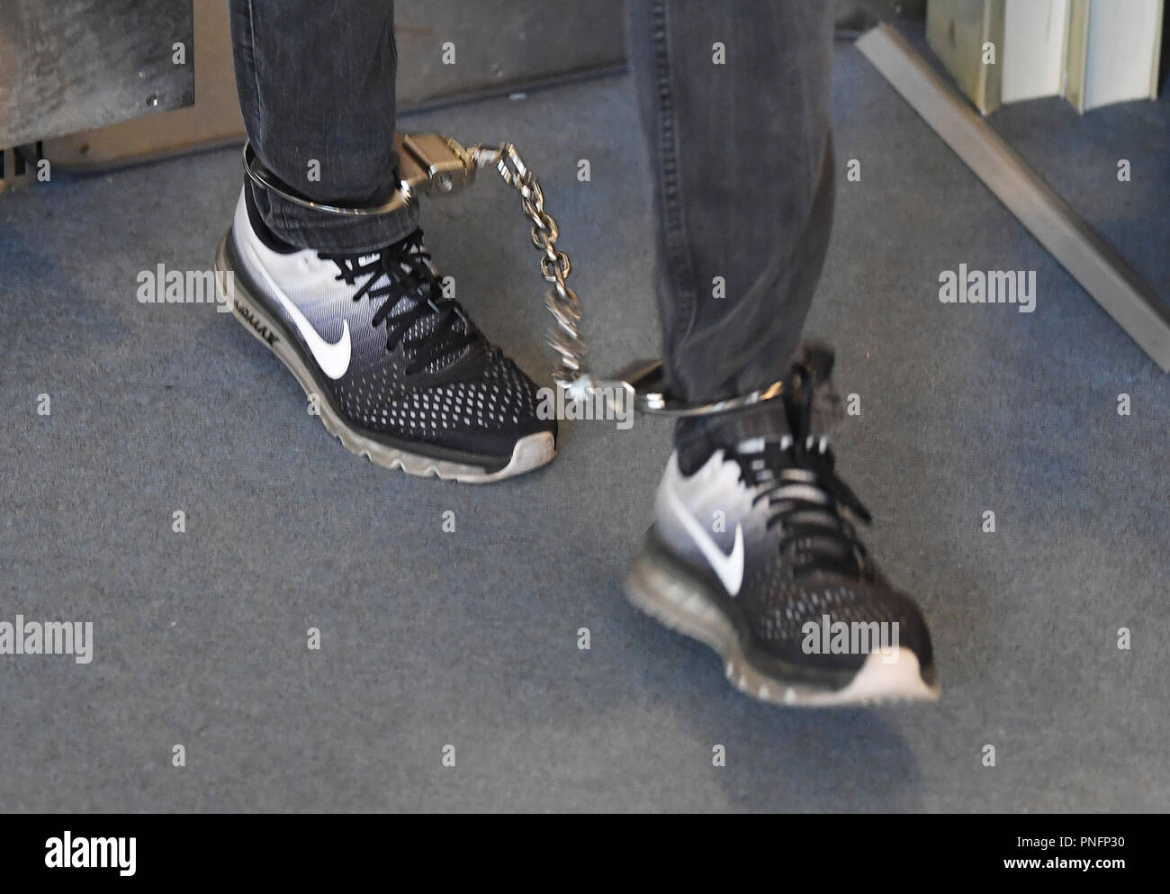 21 September 2018, Baden-Wuerttemberg, Karlsruhe: A defendant in a mafia trial is led into the courtroom of the Karlsruhe Regional Court in shackles. Nine men aged 26 to 57 living in the Black Forest Baar district, Stuttgart and Italy are accused of dealing drugs on a large scale from October 2013, some of them as organised gangs from November 2016 at the latest until their arrests in June 2017. Photo: Uli Deck/dpa Stock Photo