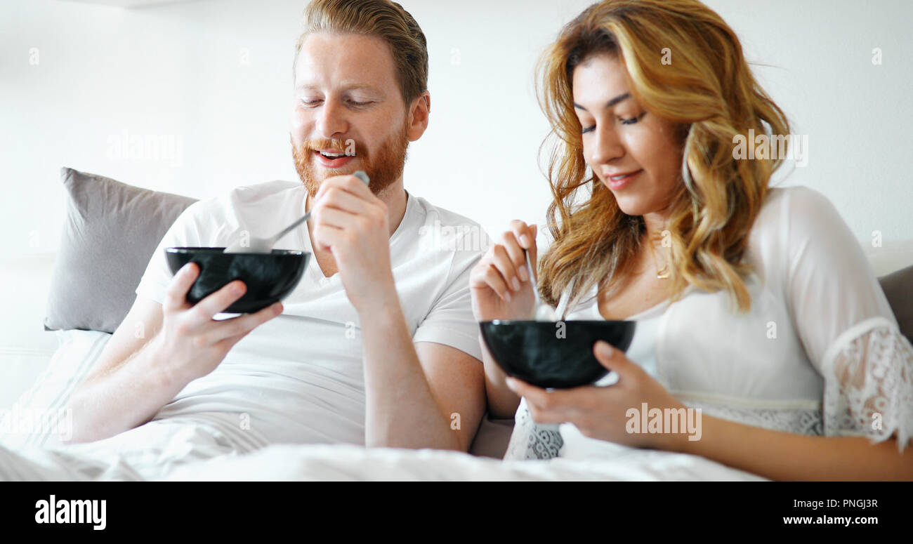 Young attractive couple having breakfast in bed Stock Photo