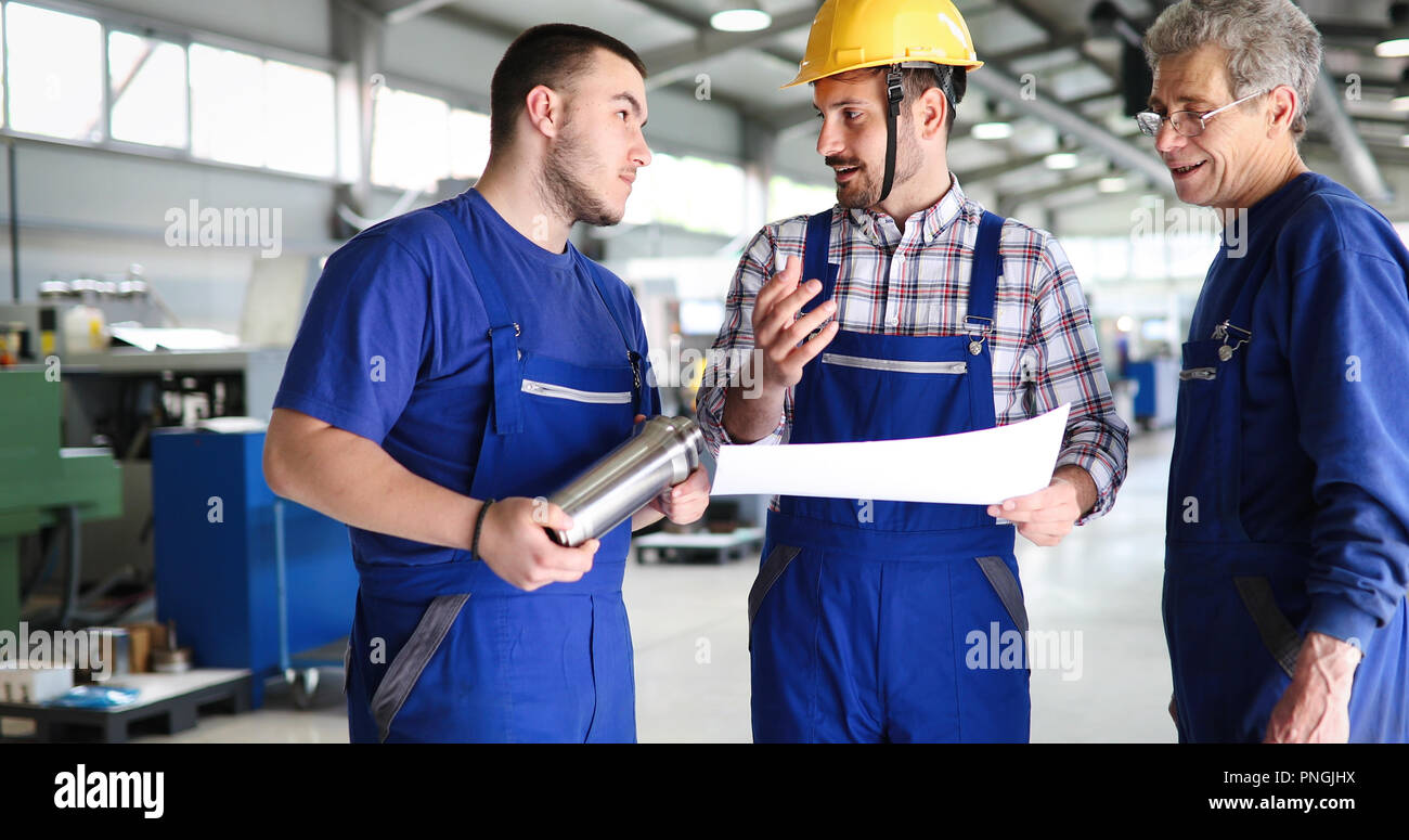 Engineer Teaching Apprentices To Use Computerized cnc metal processing machines Stock Photo