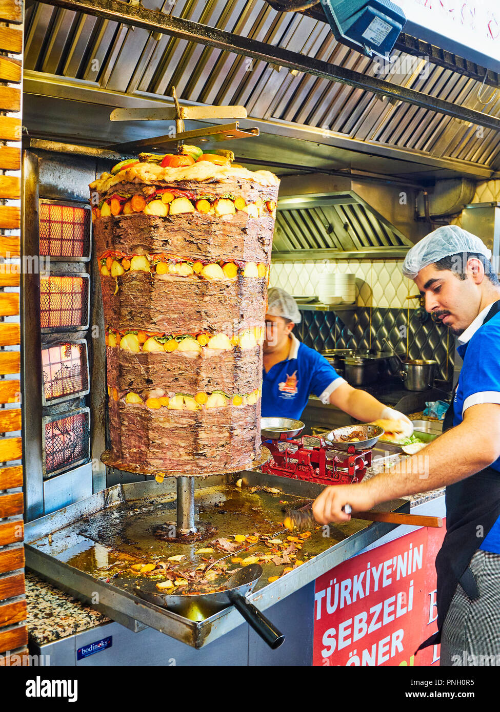 Bodrum, Turkey - July 5, 2018. Cooks cooking, cutting and weighing the rations of a traditional Turkish Doner Kebab in a street stall. Stock Photo
