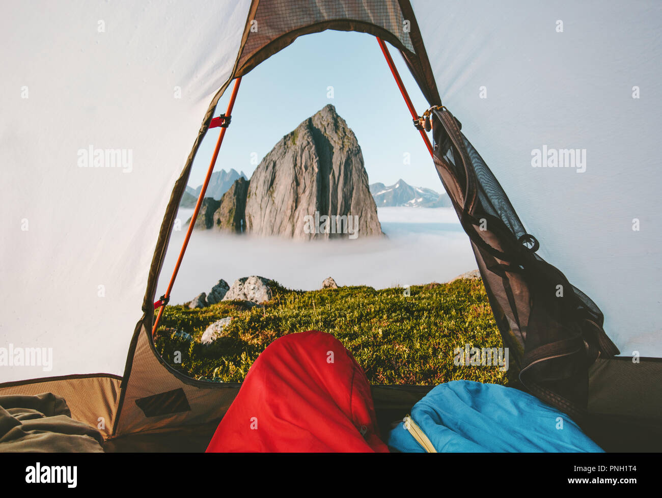Camping tent mountain morning view travel couple in sleeping bags enjoying vacations adventure lifestyle outdoor in Norway Stock Photo