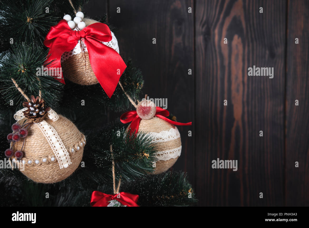 Christmas or New Year rustic wooden background with toy decorations and fur tree branch, copy space. Stock Photo