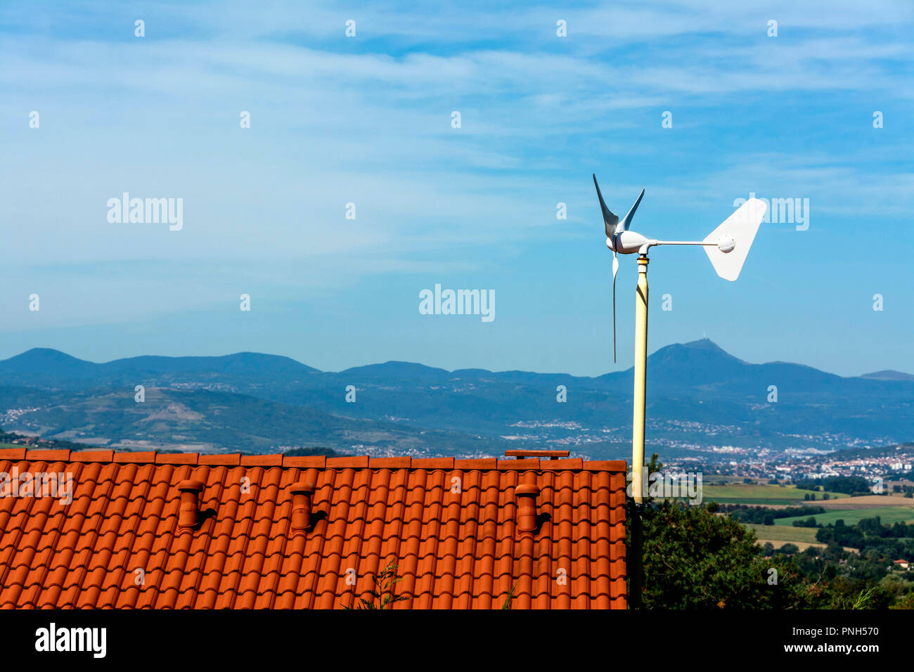 Micro wind turbine on the roof of a house, Puy de Dome department, Auvergne Rhone Alpes, France Stock Photo