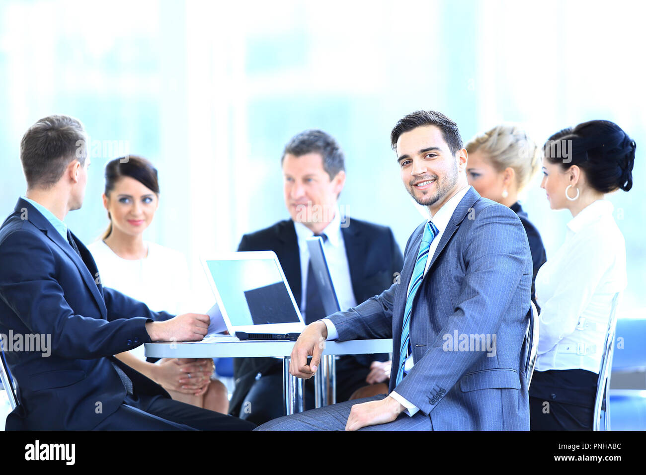 group of smiling business people sitting in a meeting room Stock Photo ...