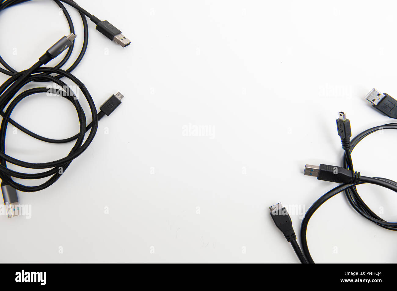 White desk with various USB cables. Stock Photo