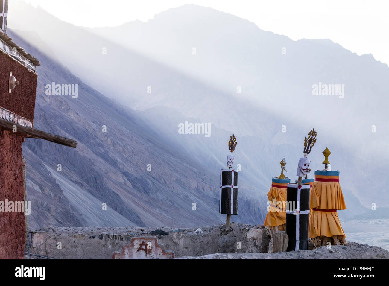 Masks and prayer wheels at the top of the Diksit monastery in the Nubra valley region of India Stock Photo