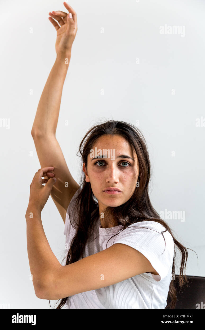 Portrait of a young Indian woman with arms raised and looking at camera. Medium close up. Stock Photo