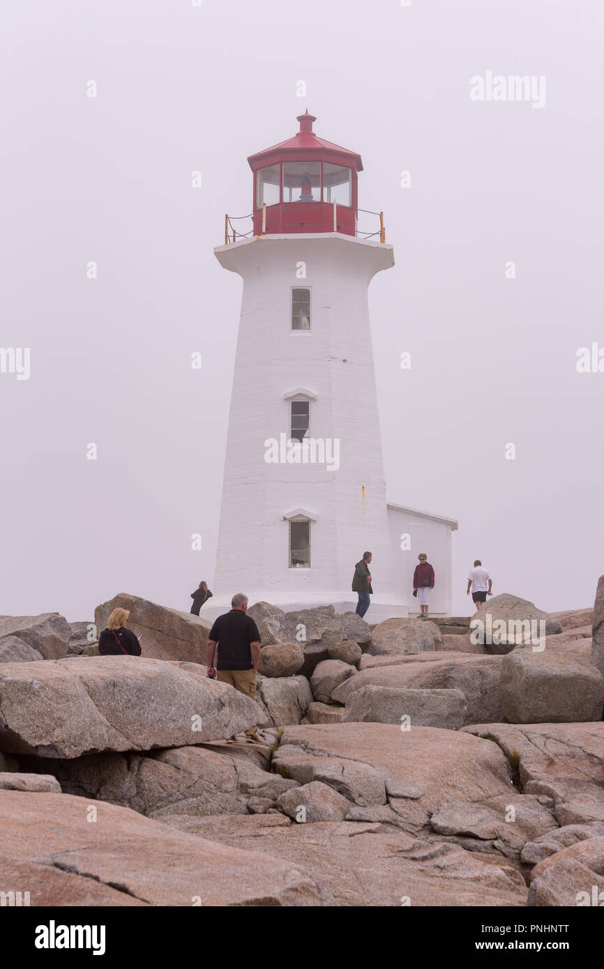 PEGGY'S COVE, NOVA SCOTIA, CANADA - Lighthouse on rocky point during fog. Stock Photo