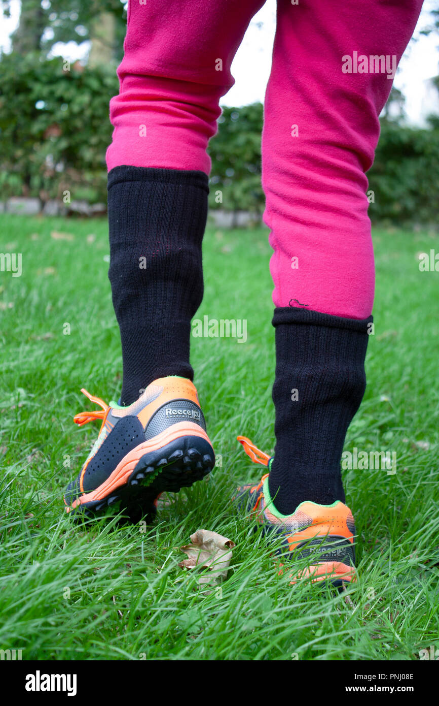 Girl wearing socks over trousers for tick bite prevention, to protect kids from Lyme diseases and other tick borne infections Stock Photo