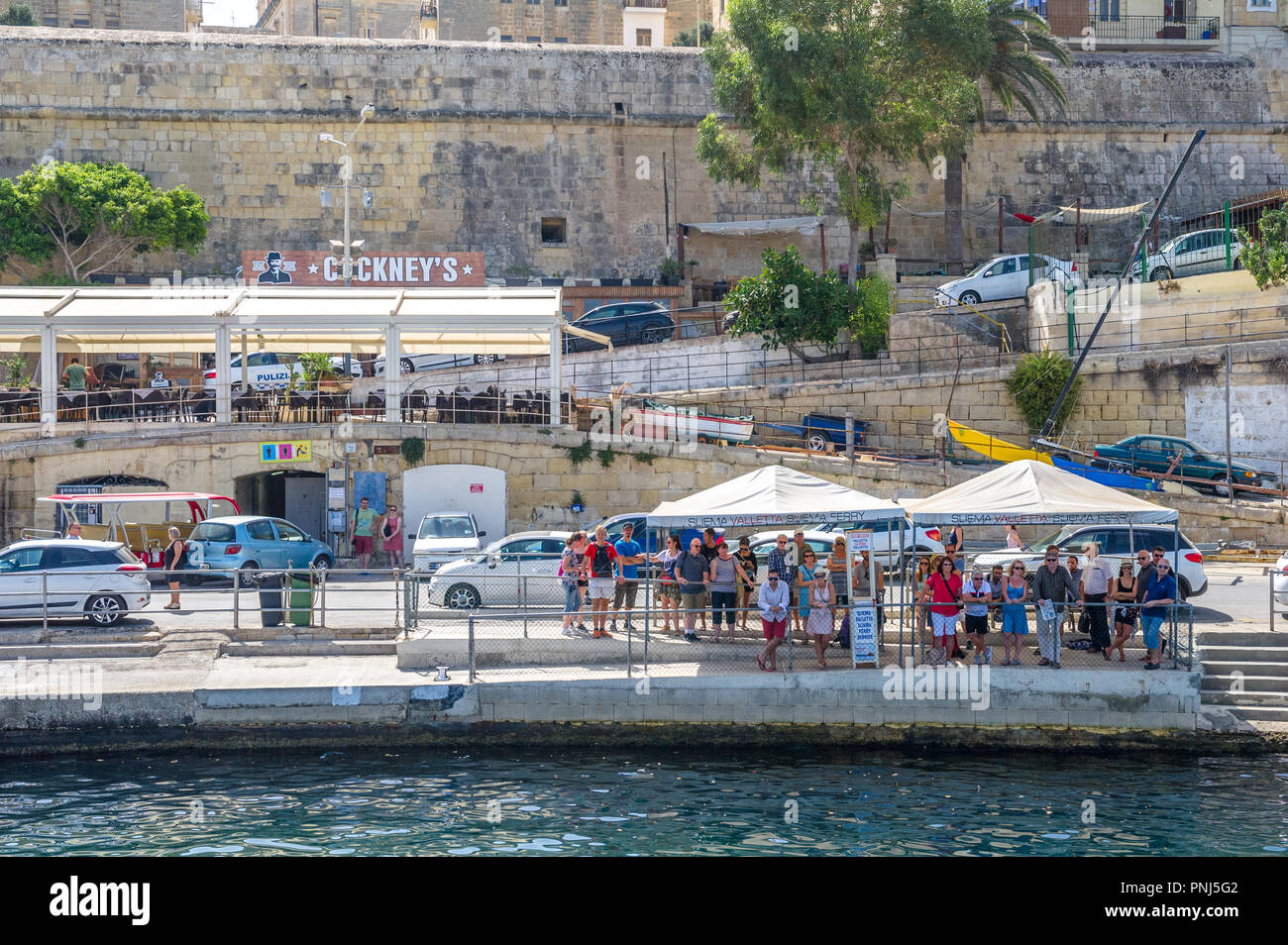 People waiting for a ferry to take them from valletta to Sliema, Malta. Stock Photo