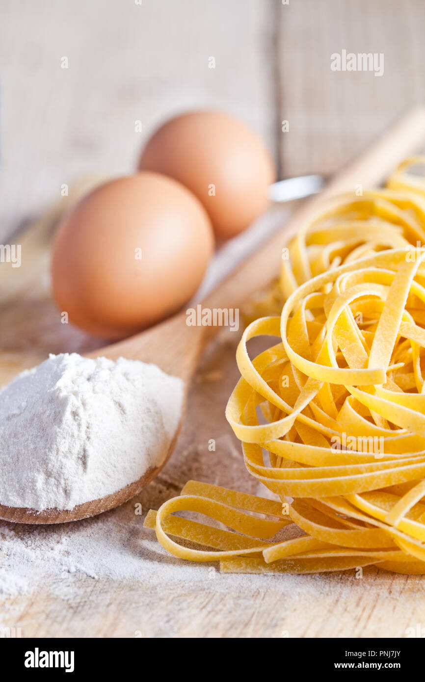 italian pasta tagliatelli, flour and eggs close up on wood table Stock Photo