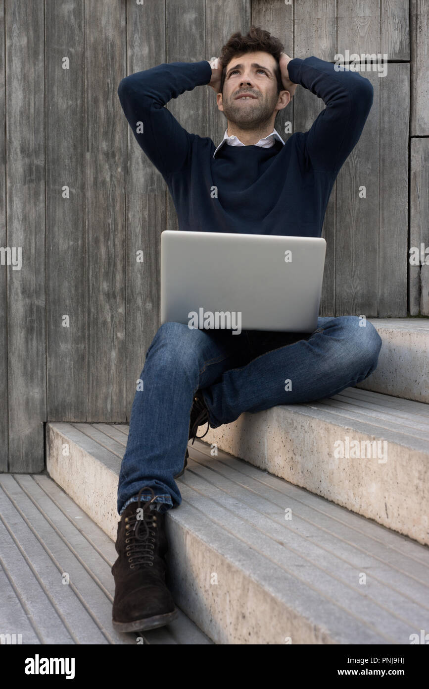 young man with laptop worried with the hands in the head Stock Photo