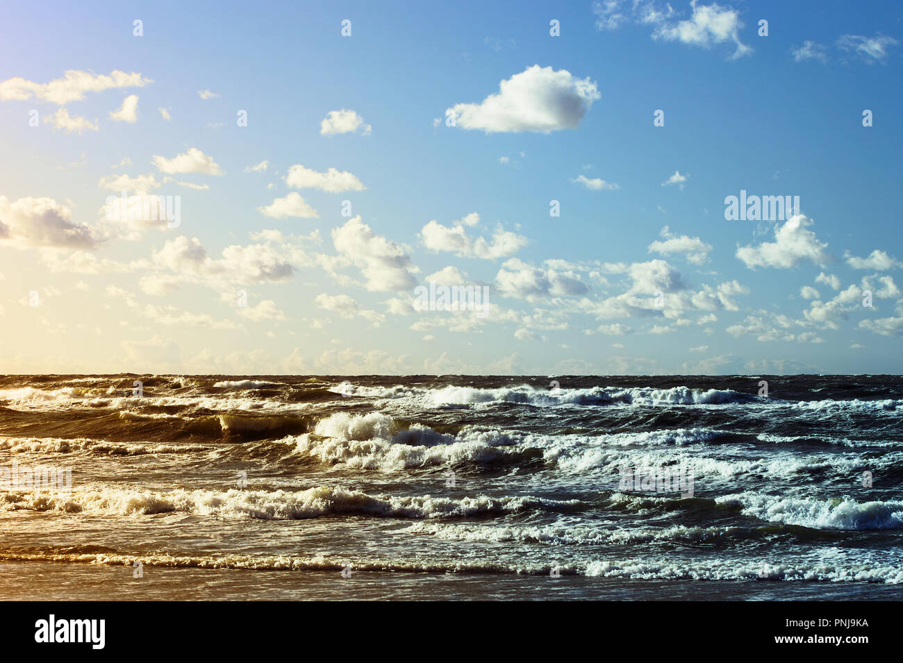 Beautiful seascape with sea waves, blue sky and white cumulus clouds. Summer vacation landscape. Baltic sea, Pomerania, northern Poland. Stock Photo