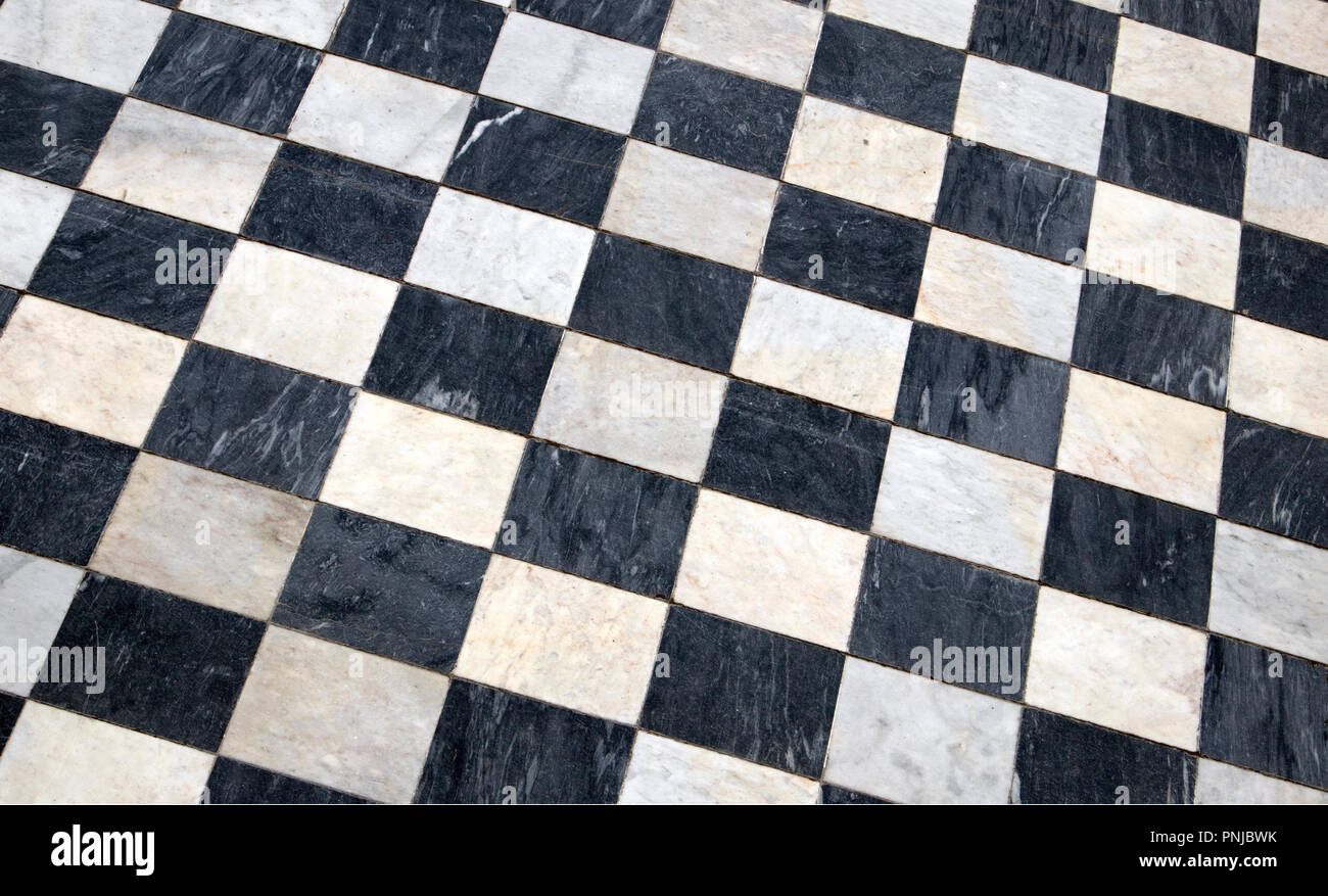 Antique checkered marble floor, black and white tiled background, diagonal view Stock Photo