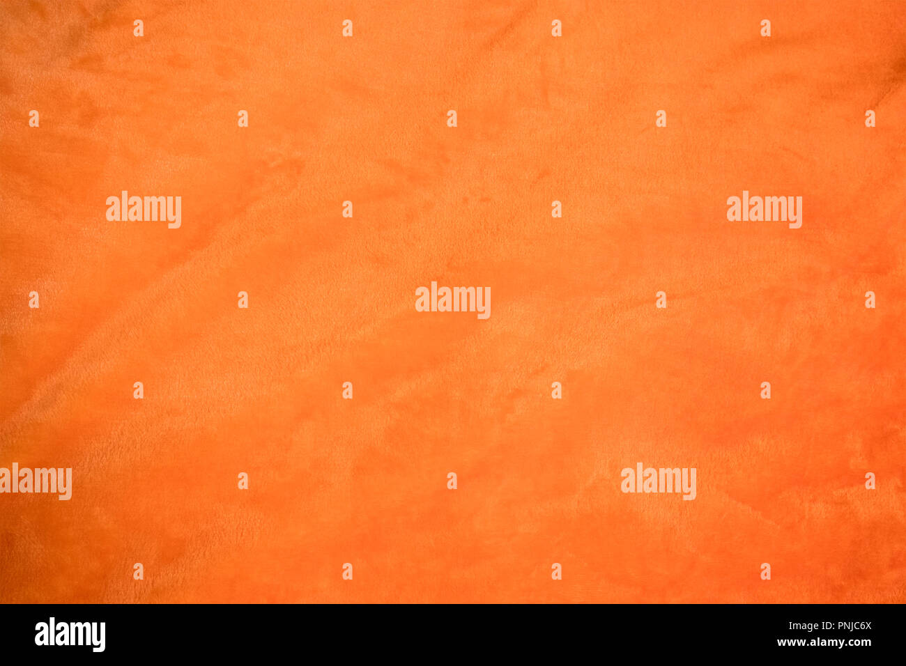 Jersey bright orange fabric with light folds closeup, may be used as background or texture Stock Photo
