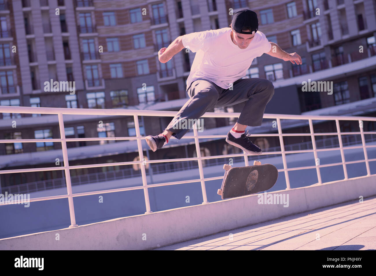 Active male person trying to jump on skateboard Stock Photo - Alamy