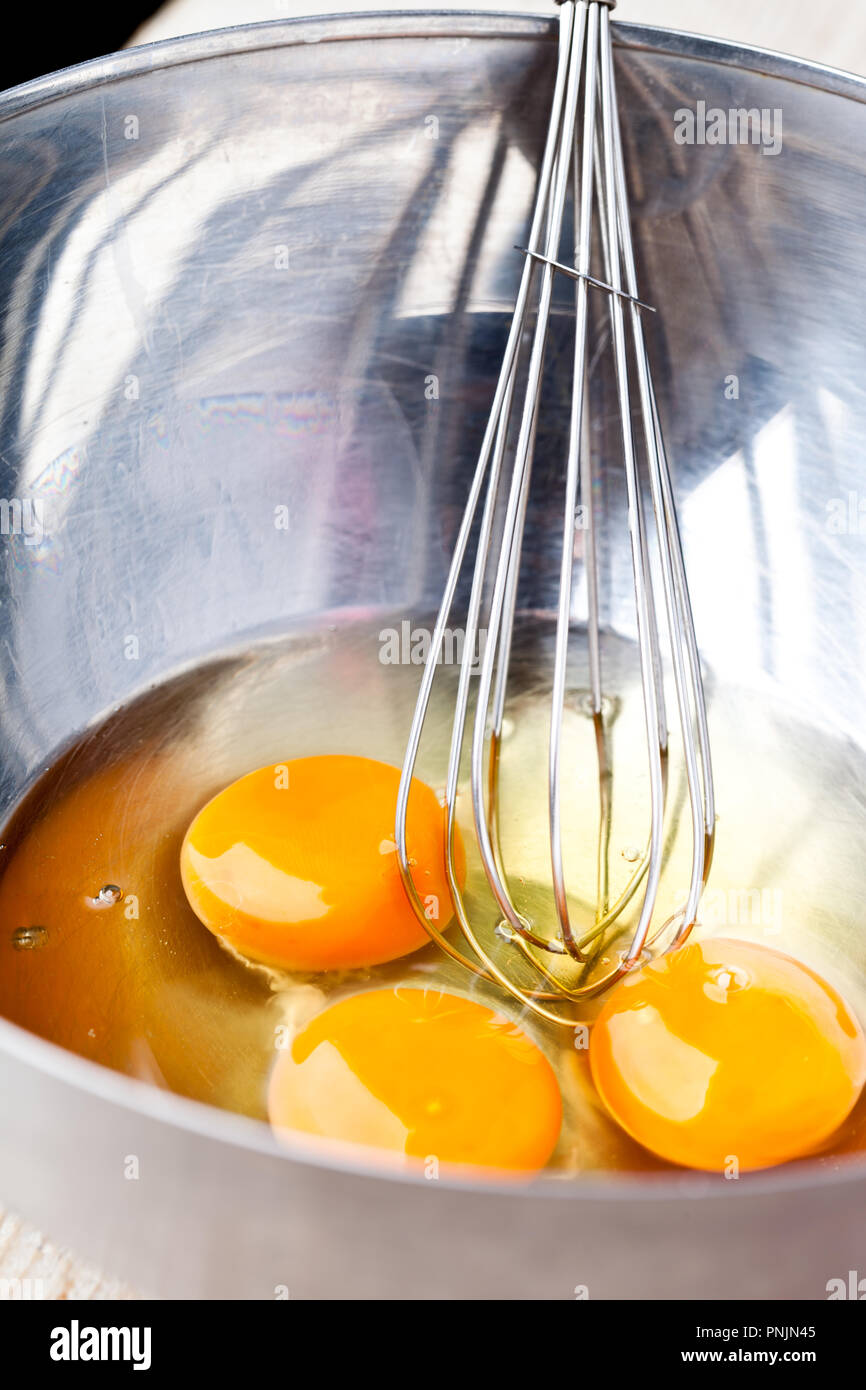 Close-up, whisking an egg white with small metal whisk