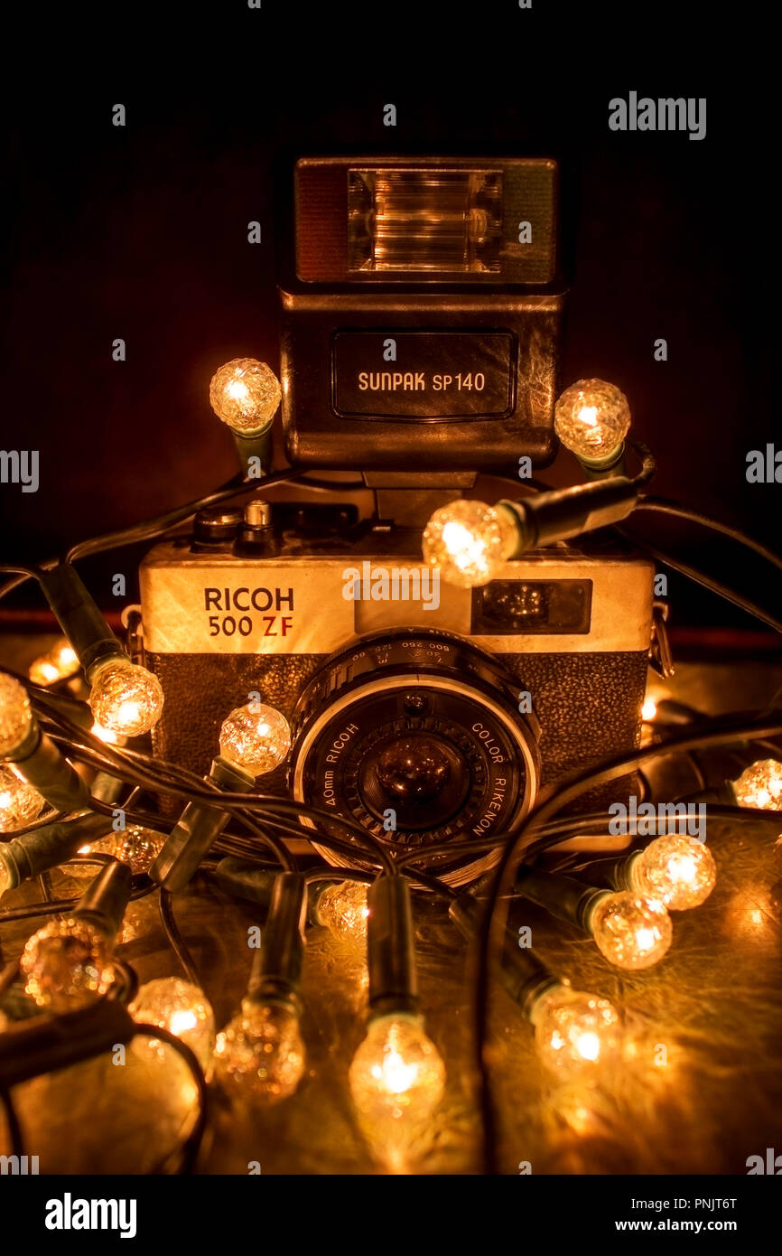 Old Ricoh Camera wrapped in Fairy Lights Stock Photo