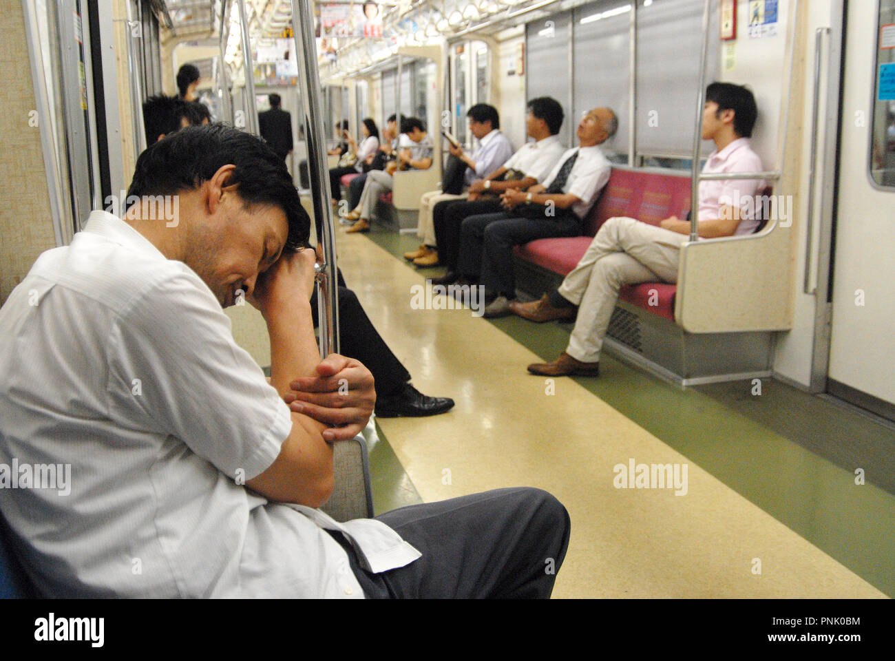 Japanese people sleeping and  riding the train early in the morning in tokyo, japan Stock Photo