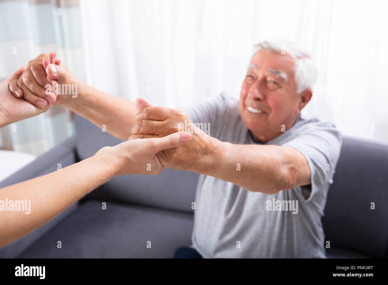 Close-up Of A Daughter Holding Hands Of Her Happy Father Stock Photo
