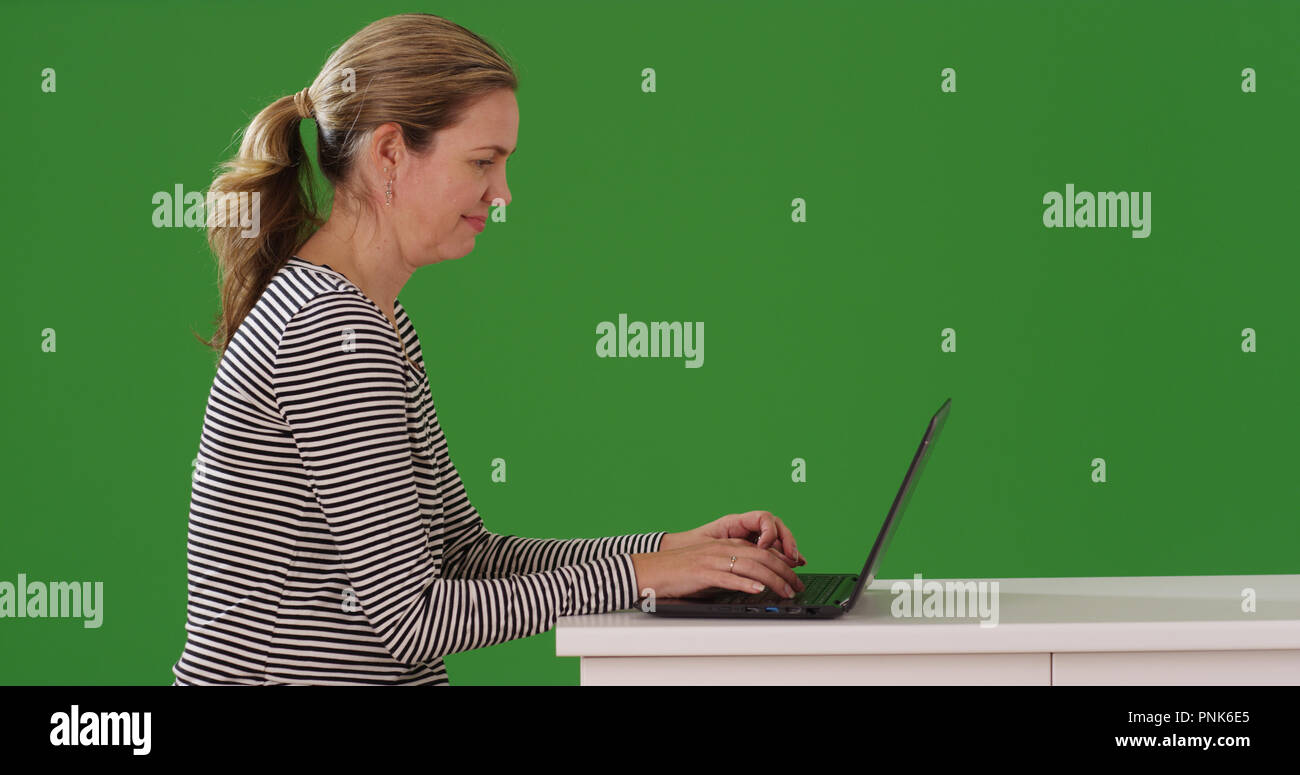 Profile of Caucasian woman working on laptop on green screen Stock ...