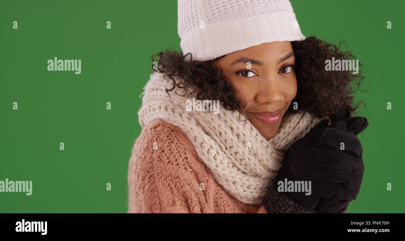 Charming black girl in cozy winter clothes smiling at camera on green  screen Stock Photo - Alamy