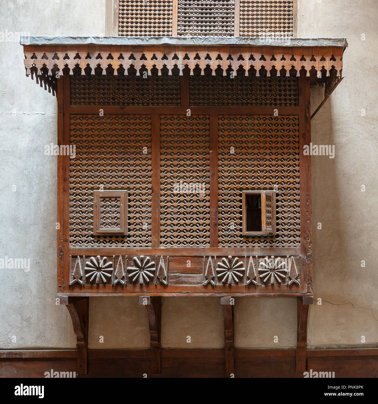 Mamluk era style oriel window covered by interleaved wooden grid (Mashrabiya) on stone wall, Facade of the House of Egyptian Architecture Stock Photo