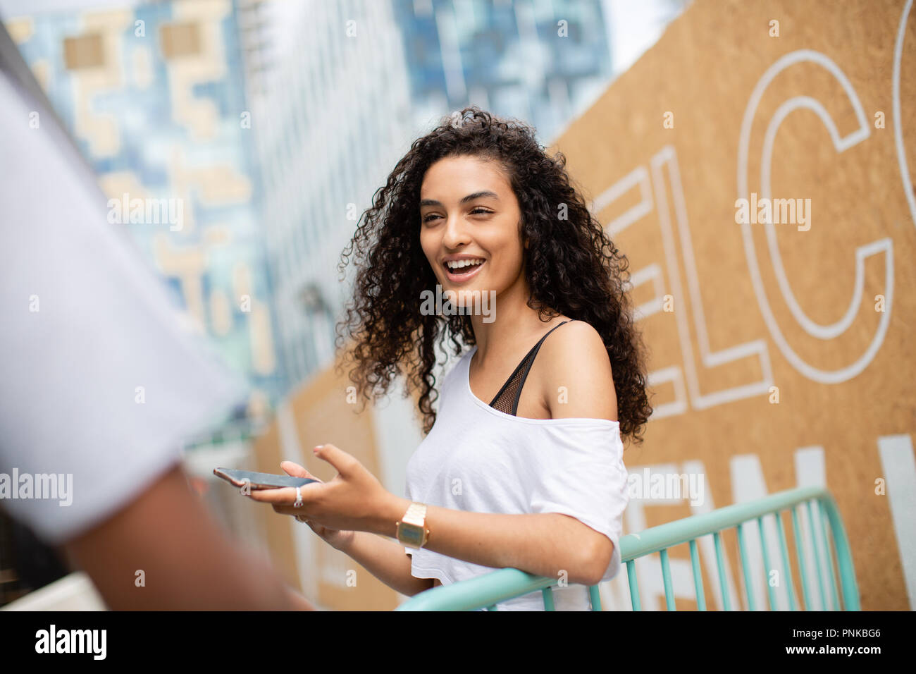 Teenagers socialising outdoors in city Stock Photo
