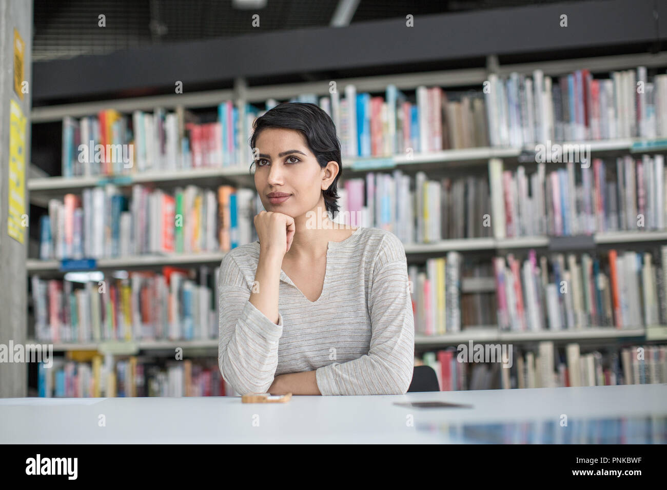 Arabic female thinking in library Stock Photo