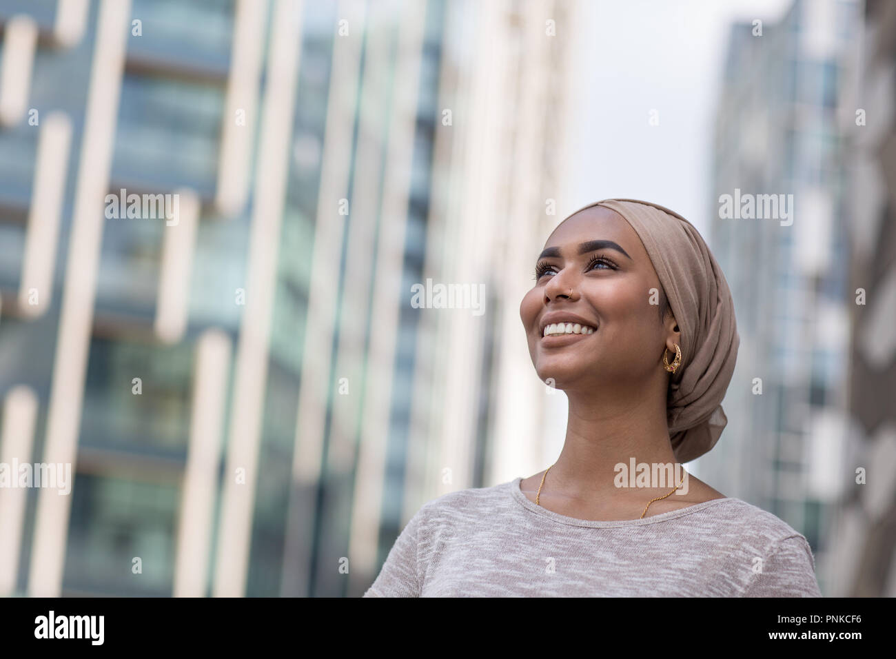 Muslim businesswoman walking through modern city Stock Photo