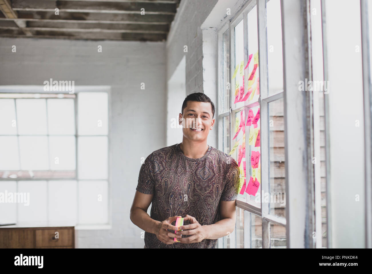 Portrait of young adult male brainstorming in a creative office with adhesive notes Stock Photo