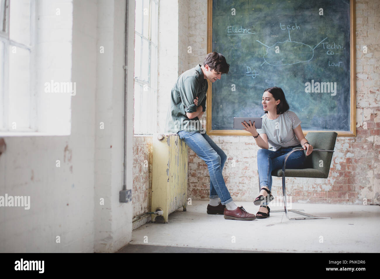 Young adults in a meeting in a creative studio with a digital tablet Stock Photo