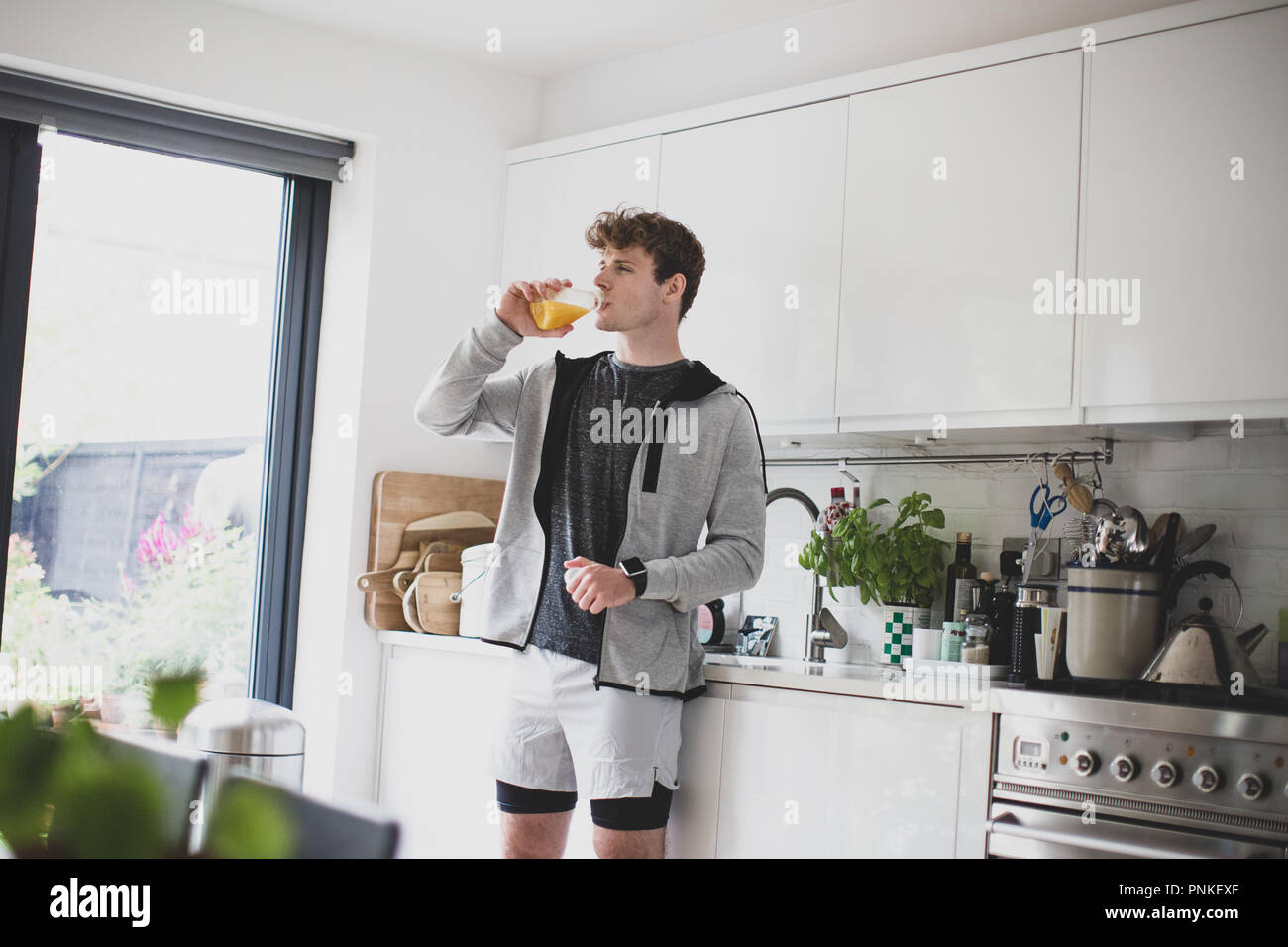 Young adult male drinking orange juice before after a run Stock Photo