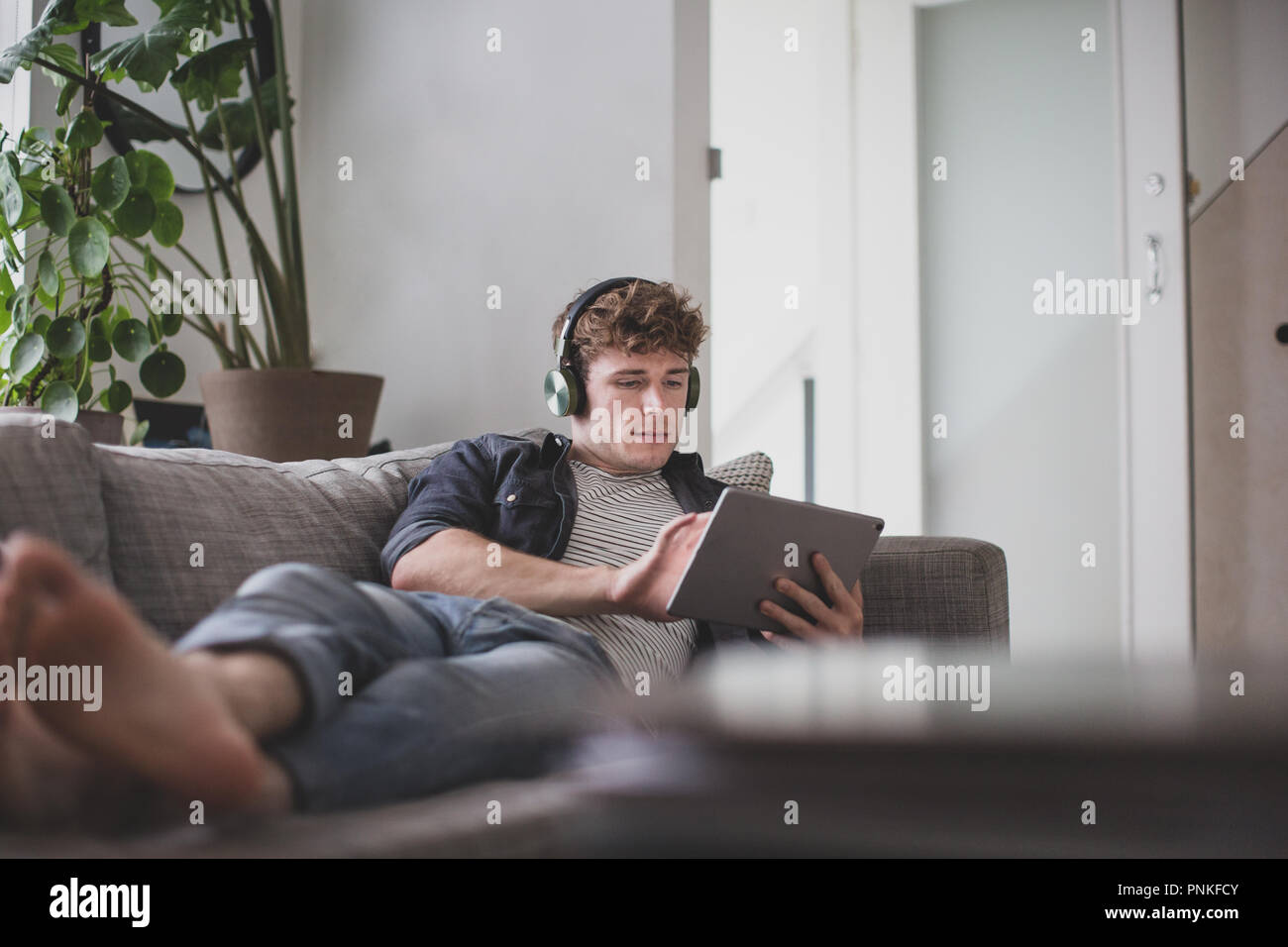 Young adult male watching video on digital tablet Stock Photo