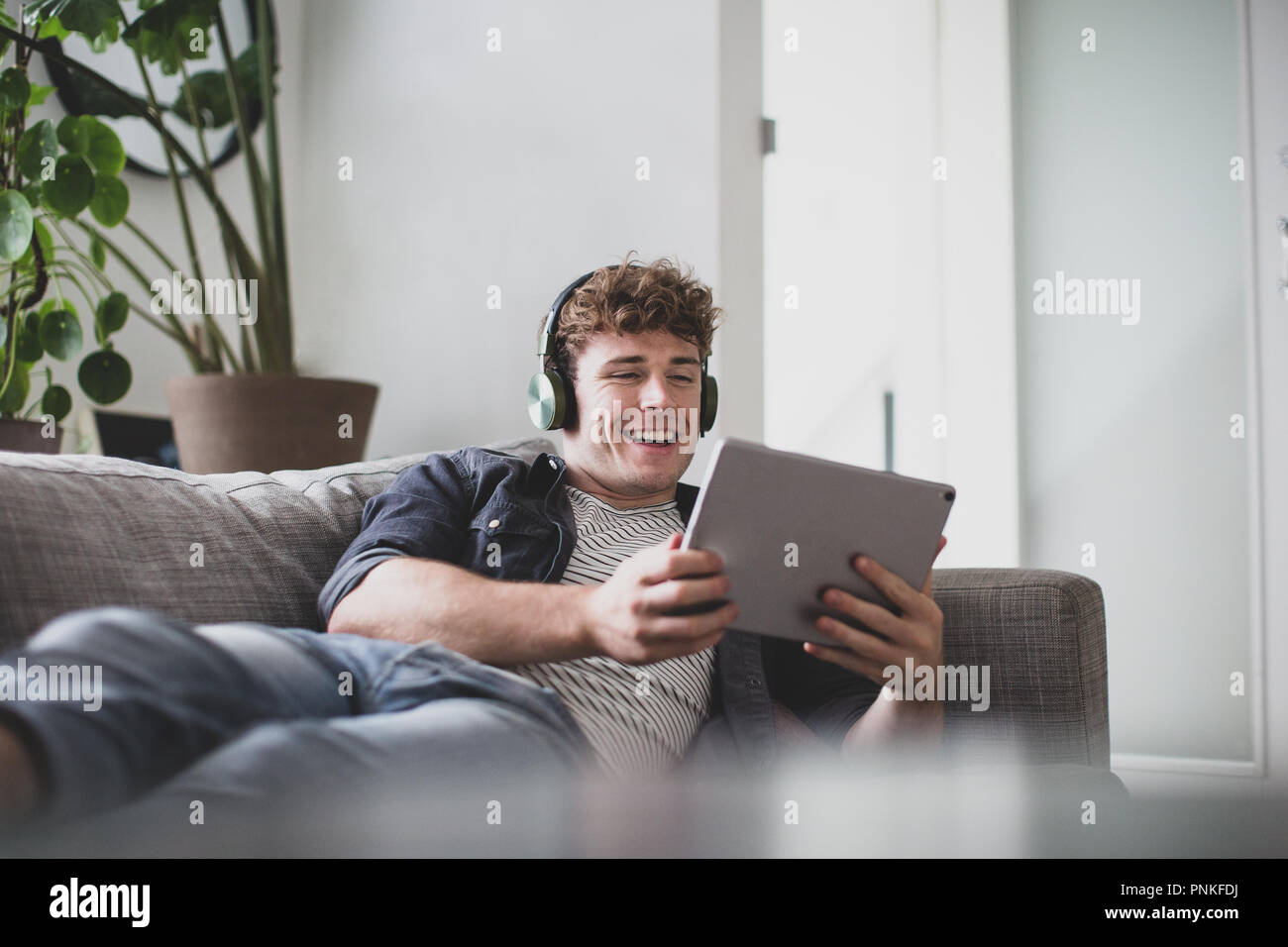Young adult male watching video on digital tablet Stock Photo