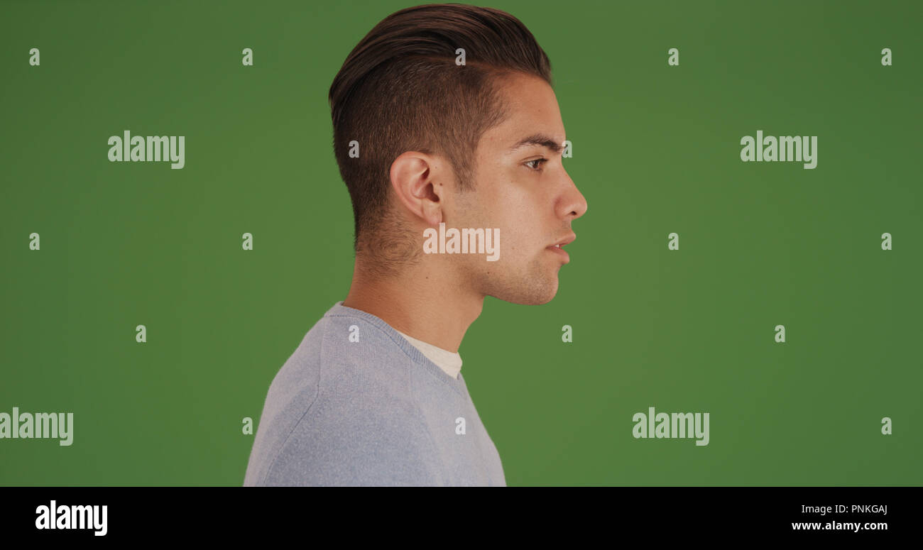 Side view of young millennial Latino man with on green screen Stock Photo