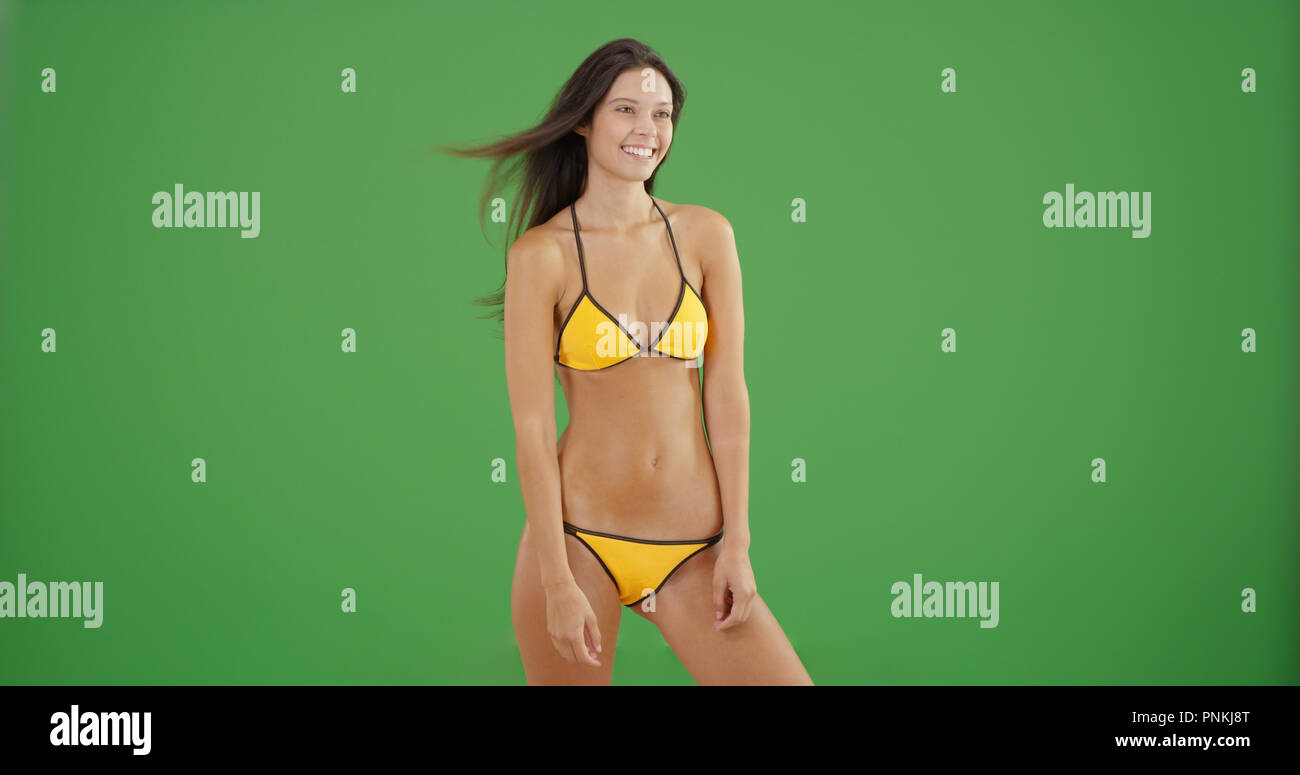 Pretty Caucasian bikini girl standing and smiling on green screen Stock Photo