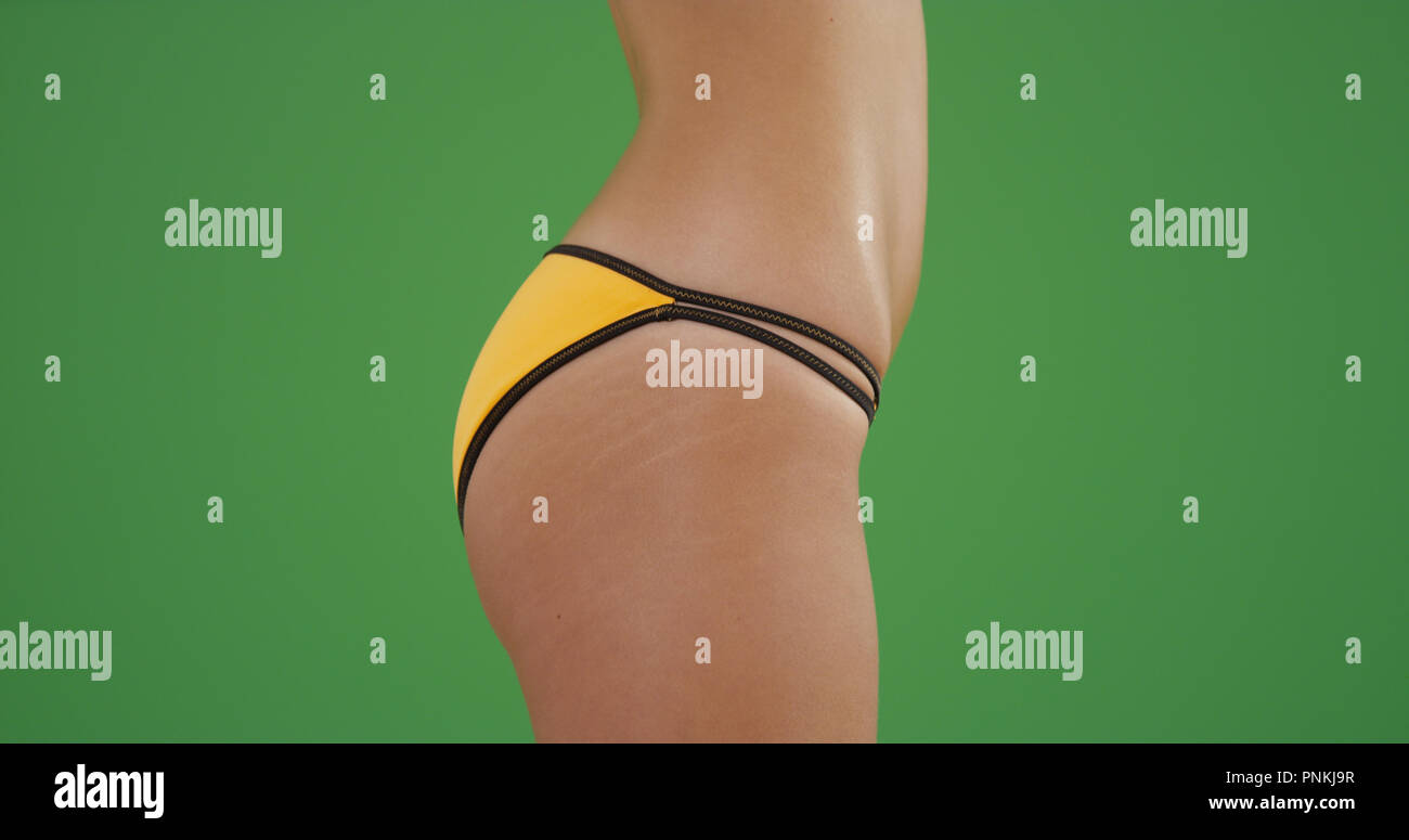 Close-up side view of millennial bikini girl's hips on green screen Stock Photo