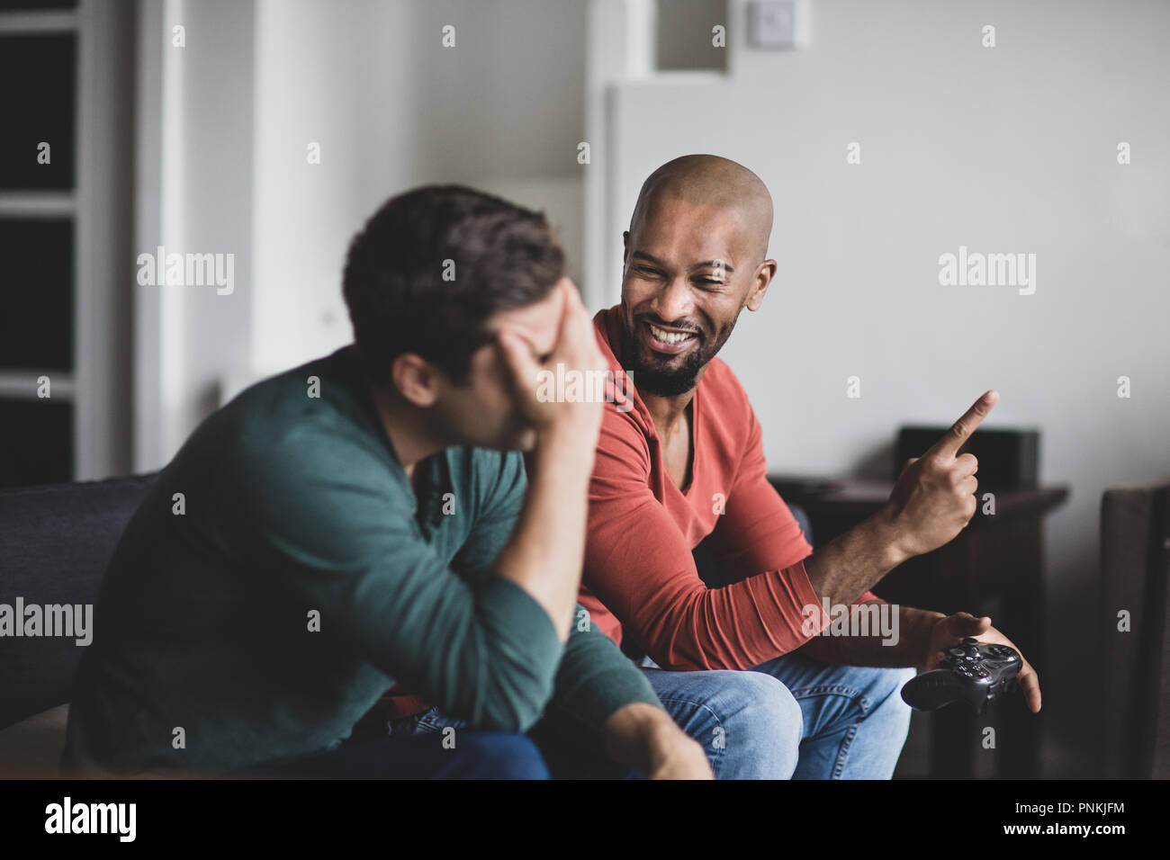 Male friends playing on a games console Stock Photo