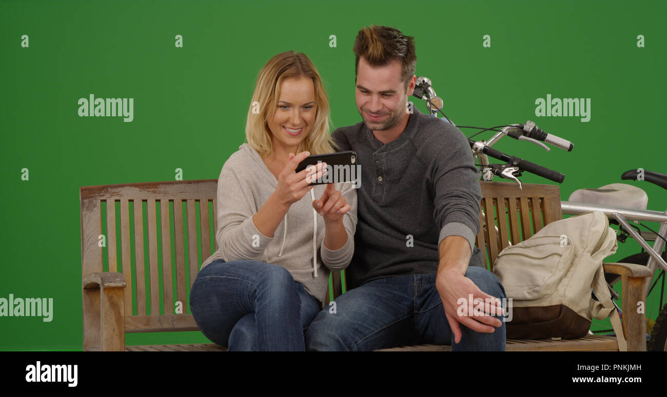 Happy Couple On Park Bench Watching Videos On Smartphone On Green Screen Stock Photo Alamy