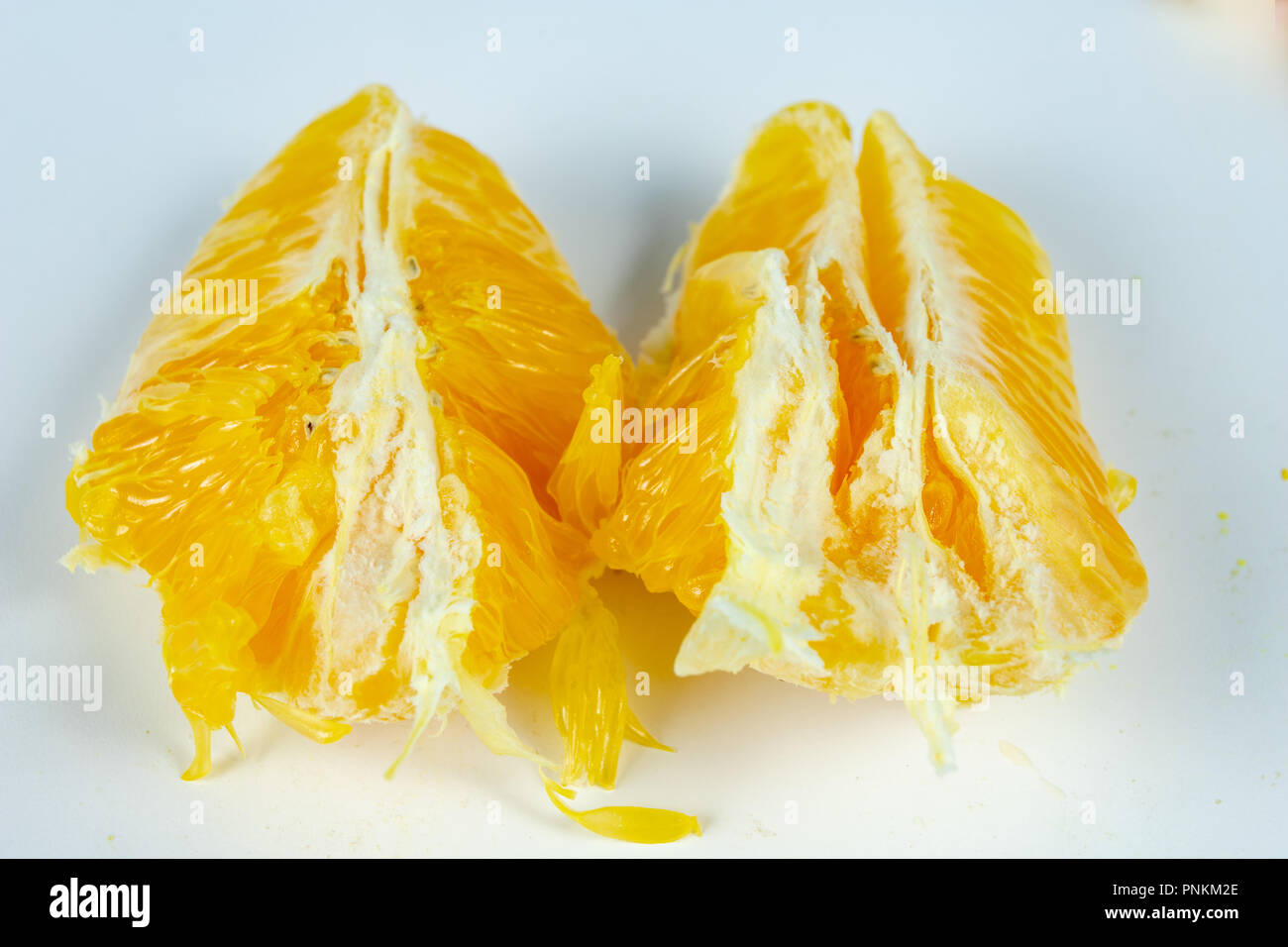 Peeled orange with very thick skin on a white kitchen table. Citruses ...