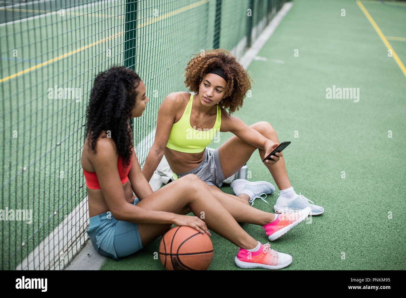 Friends taking a break from training on a basketball court Stock Photo