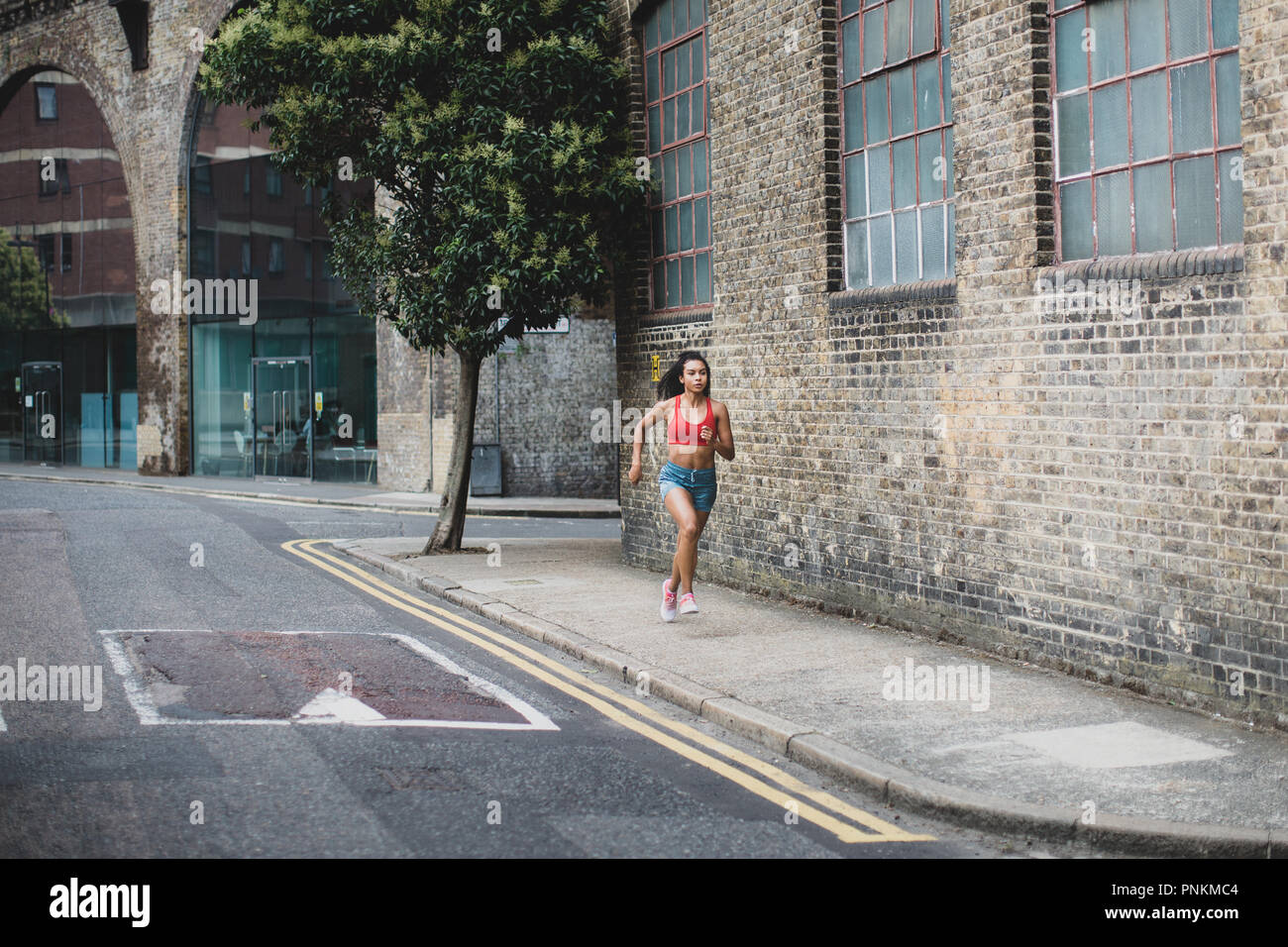 Young adult female running in urban city Stock Photo
