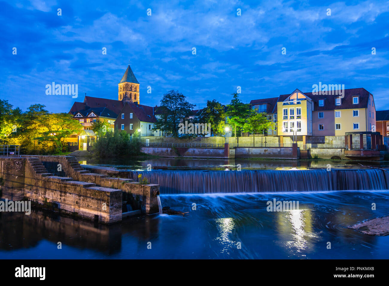 Rheine, Germany - September 5, 2018: night view of locks on Ems river, belfry tower of medieval Sankt Antonius Basilica in the backgroung Stock Photo