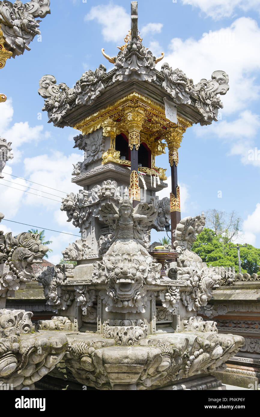 Balinese Hindu family shrine or temple ornately covered with gold showing many effigies of gods and demons. Stock Photo