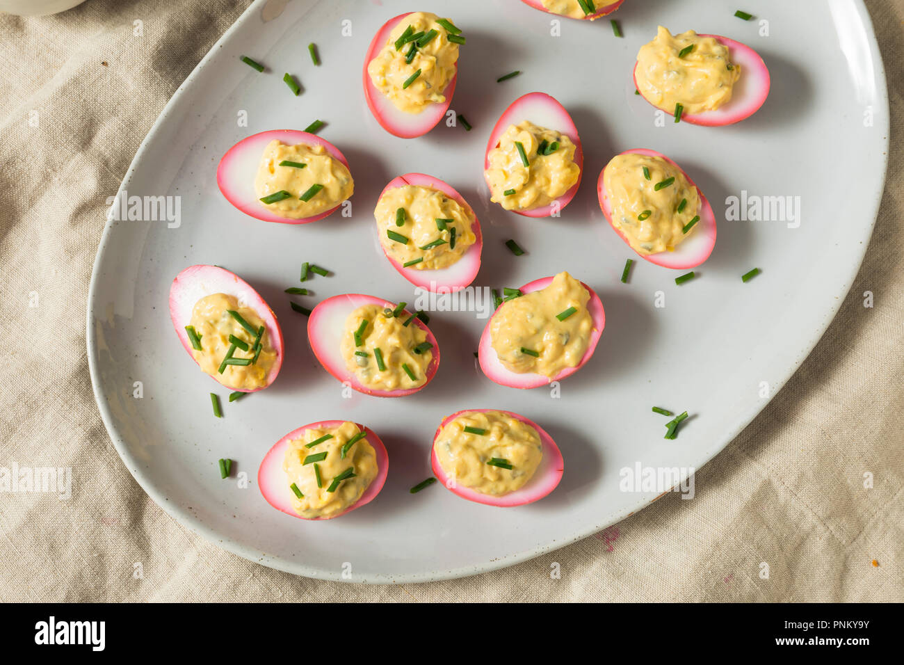 Homemade Pink Pickled Deviled Eggs with Chives Stock Photo